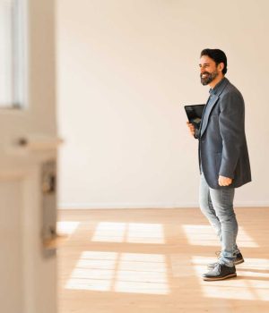 An entrepreneur, a handsome businessman is looking around in his brand new office space. Feeling confident and proud of his achievements.